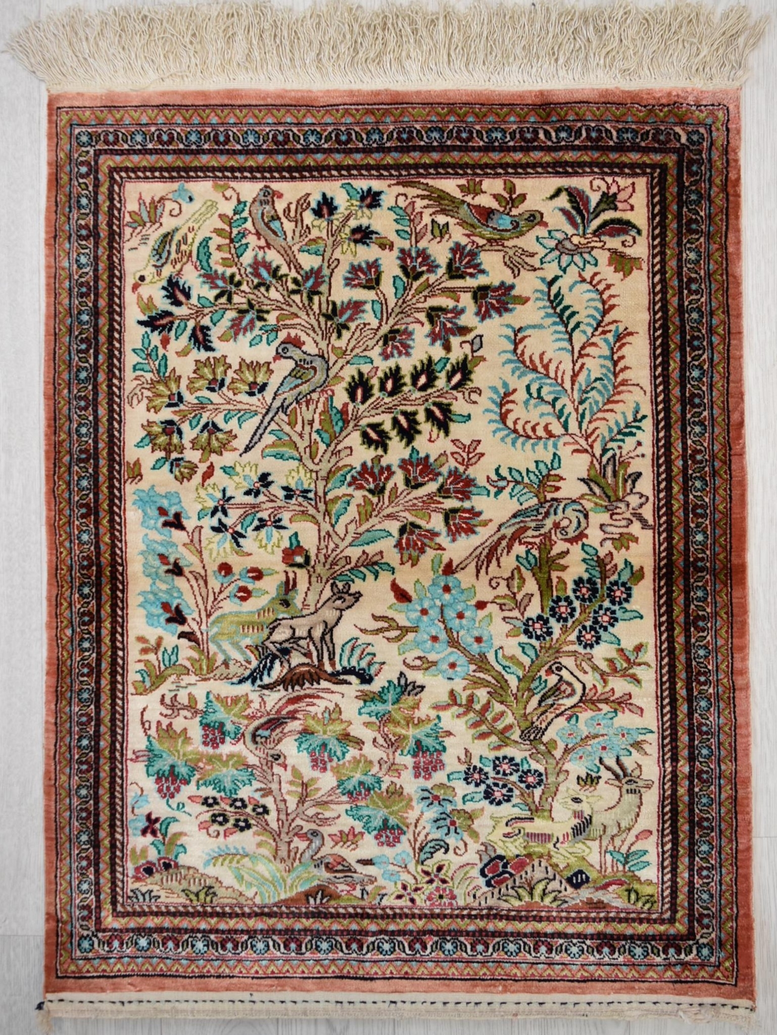 A Persian/Iranian silk Qum (Qom) rug, the central ivory field with tree of life and bird
