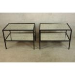 A contemporary pair of rectangular metal framed and glass two tier lamp tables raised on square