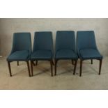 A set of four teak framed upholstered dining chairs raised on tapering supports.