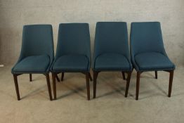 A set of four teak framed upholstered dining chairs raised on tapering supports.