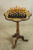 A late 19th century walnut games table with chessboard design with central twisted column raised