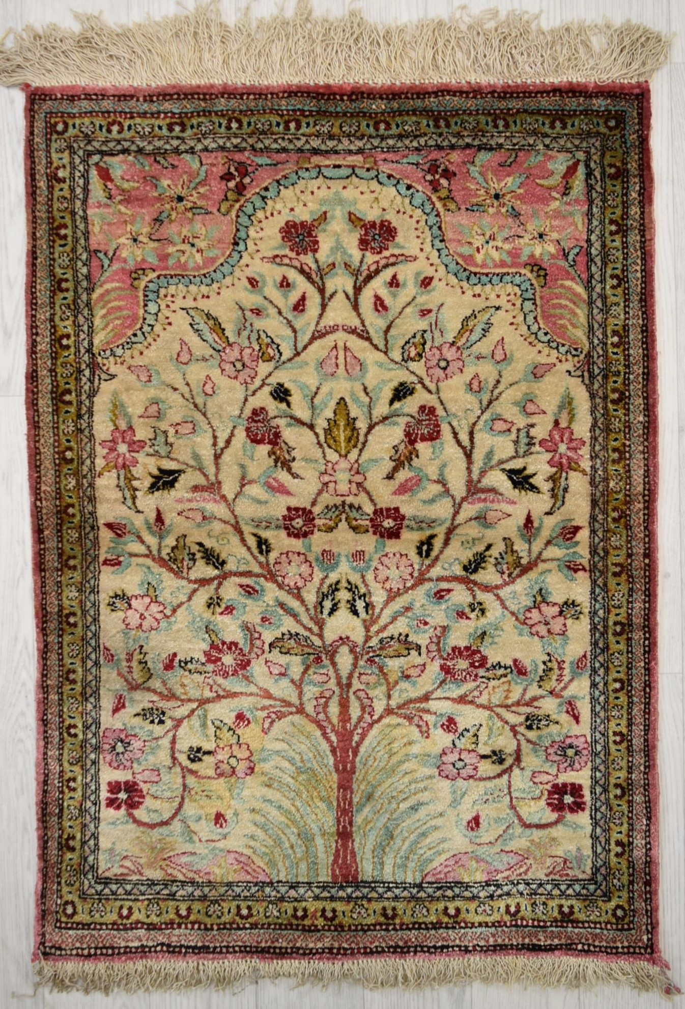 A Persian/Iranian silk Qum (Qom), the central ivory field with tree of life design within floral