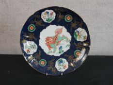 A Chinese porcelain charger decorated with central panel with dragon decoration, the inner rim