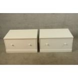A pair of white single drawer storage units with turned knob handles raised on plinth bases. H.39