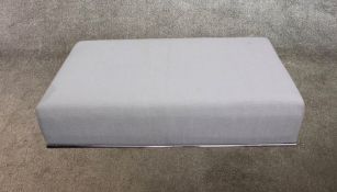 A contemporary white cotton upholstered rectangular ottoman on a chrome framed base.