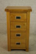 A contemporary oak chest of drawers with iron swing handles raised on rectangular feet. H.100 W.