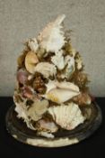 A 20th century sculpture made from assorted seashells raised on circular base. H.39 Dia.34cm.