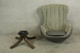 A contemporary grey upholstered adjustable swivel egg chair raised on four mahogany effect splayed