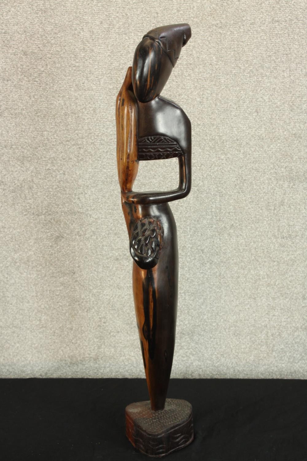 A 20th century carved African hardwood tribal figure raised on shaped base. H.73cm.