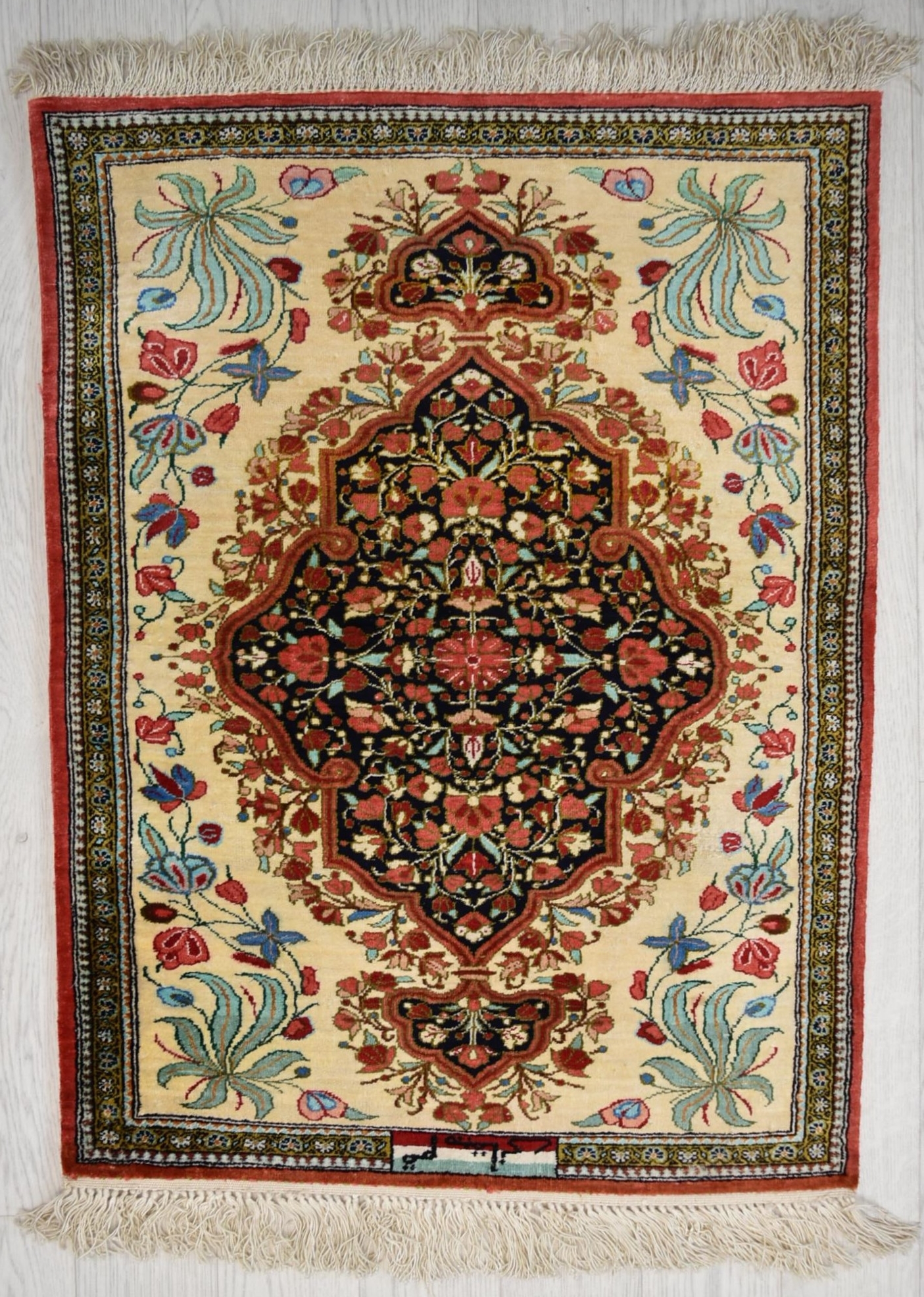 A Persian/Iranian silk qum rug, the blue central lobed panel with stylised floral decoration on