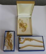 A collection of boxed gold plated stainless steel and silver chain necklaces with various designs.