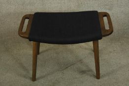 After Hans Wegner; a walnut show framed Teddy Bear foot stool raised on splayed tapering supports.