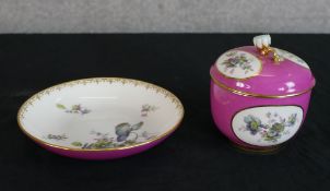 A 19th century German KPM porcelain lidded sugar bowl and saucer, decorated with panels of floral