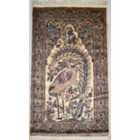 A Persian silk and wool tree of life rug, the ivory field with a crane and assorted flowers within a