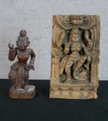 A 20th century Indian hardwood panel carved with a godess together with a carved Balinese hardwood