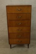A mid 20th century Meredew teak six drawer tallboy with brass handles raised on tapering supports