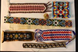 A collection of seven pieces of Danish beadwork, each with geometric patterns. L.56cm. (largest0