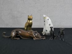 A 20th century patinated bronze figure of a crouching dog, together with two other dogs, a 20th