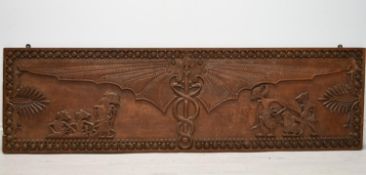 A South East Asian carved hardwood panel depicting bat wings with intertwining snakes and mythical