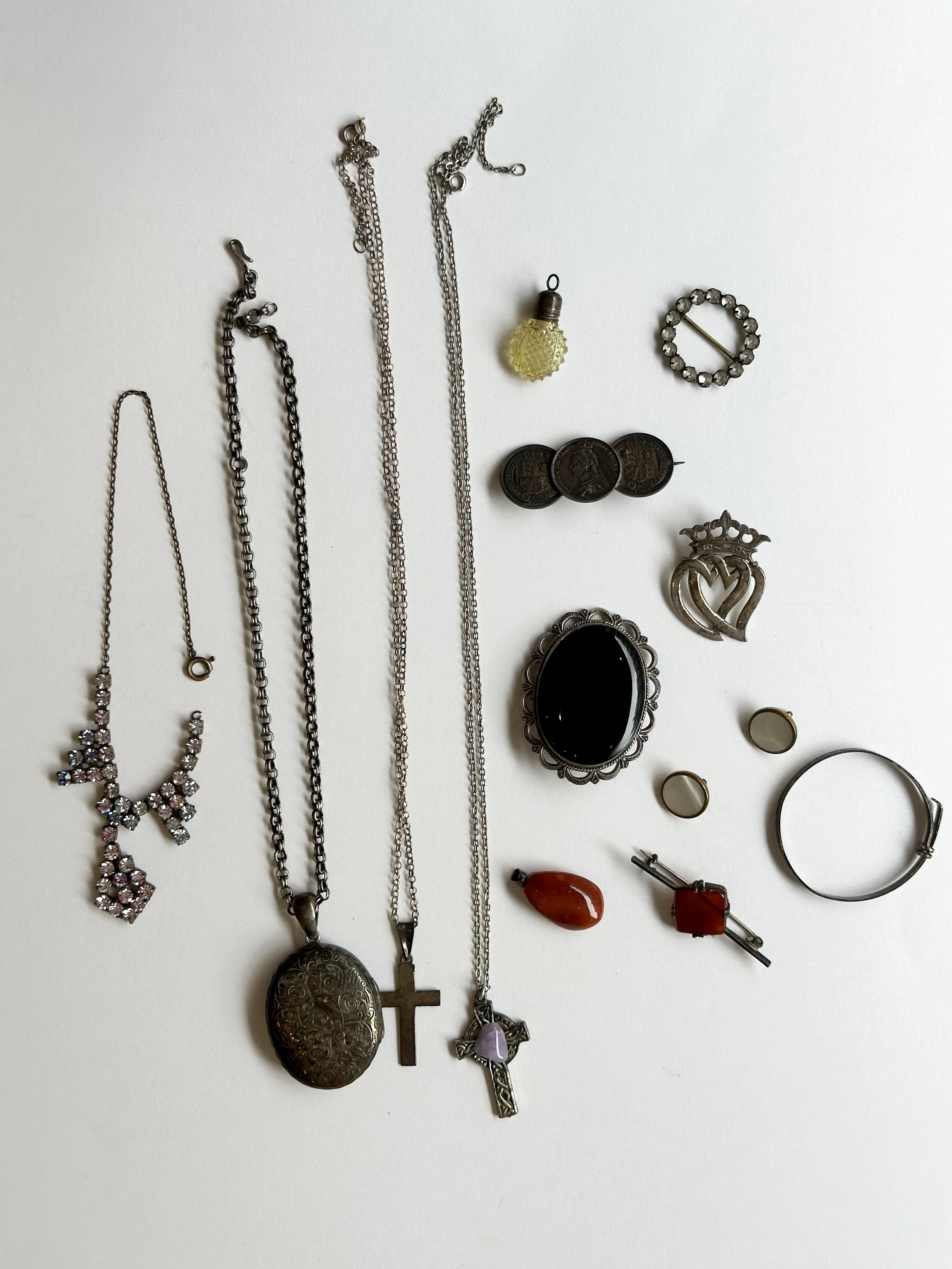 A collection of silver and costume jewellery, including a Victorian silver coin brooch, an amber