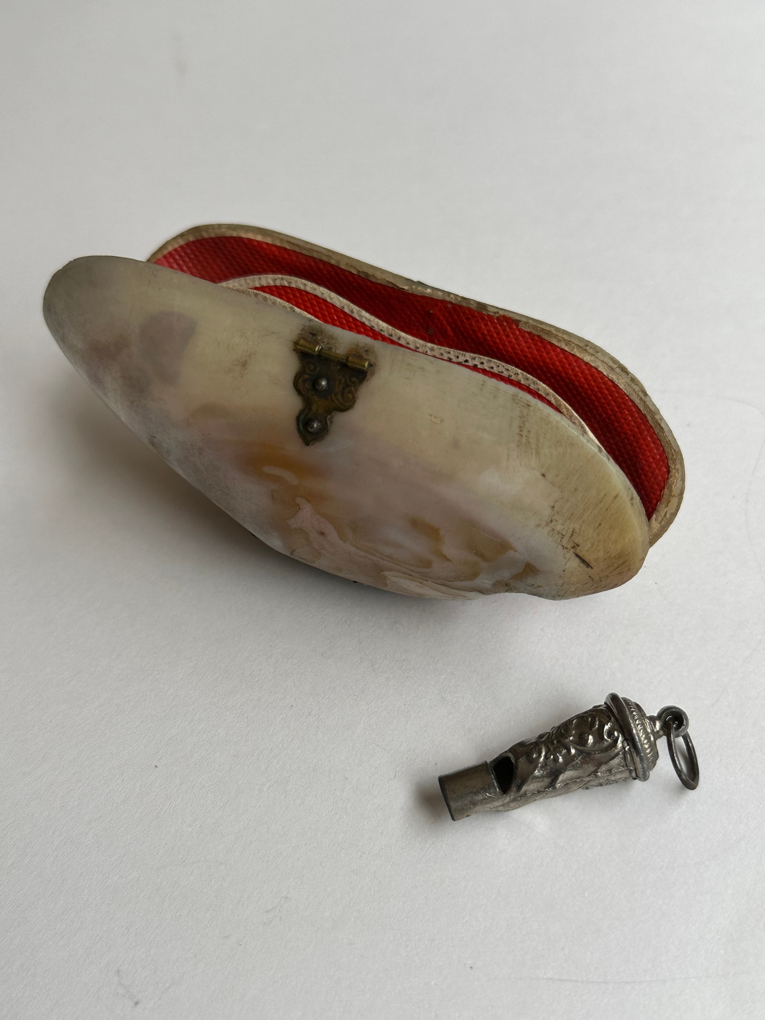 An early 20th century clam shell hinged purse with red lining along with a French miniature whistle. - Image 4 of 4