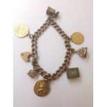 A 9 carat rose gold curb link charm bracelet with an inscribed heart padlock clasp. Bracelet has 7