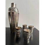 A Chinese silver repousse cocktail shaker and four matching shot glasses. The cocktail shaker
