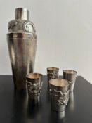 A Chinese silver repousse cocktail shaker and four matching shot glasses. The cocktail shaker