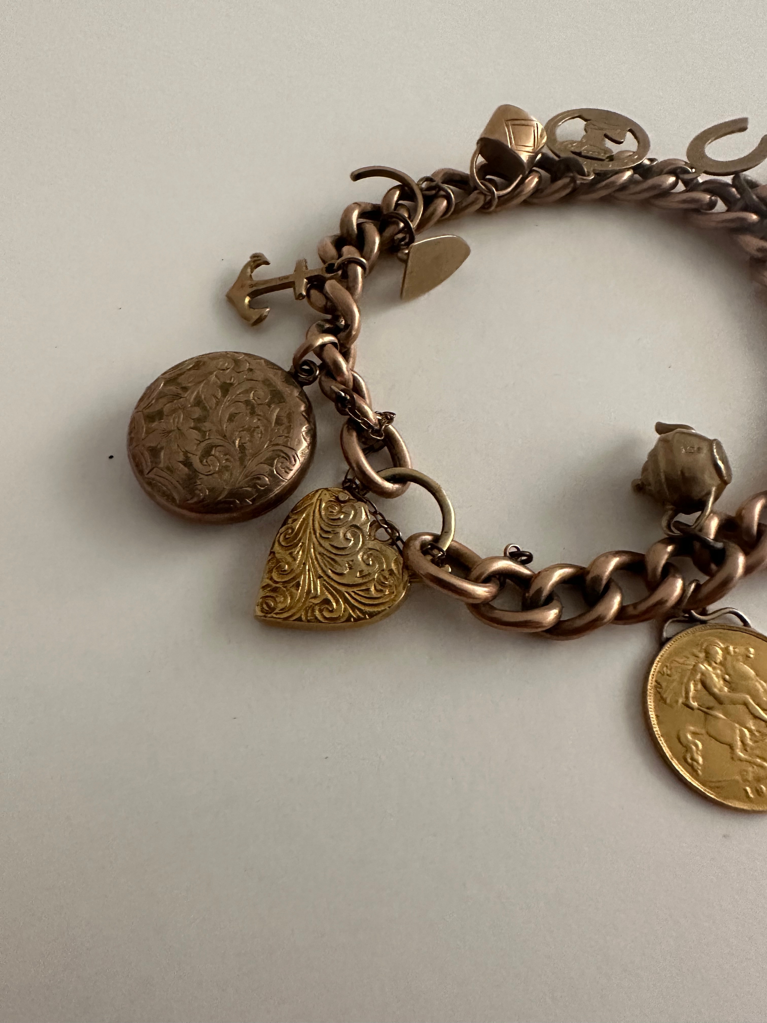 A 9 carat rose gold curb link charm bracelet with engraved heart padlock clasp. Bracelet has 13 - Image 2 of 4