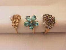 Three 20th century 9 carat and 10 carat yellow gold gem-set rings: a blue topaz floral ring, a
