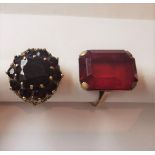 Two 9 carat yellow gold and red metal dress rings. One set with a large red paste stone, the other a