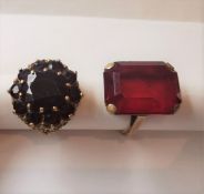 Two 9 carat yellow gold and red metal dress rings. One set with a large red paste stone, the other a