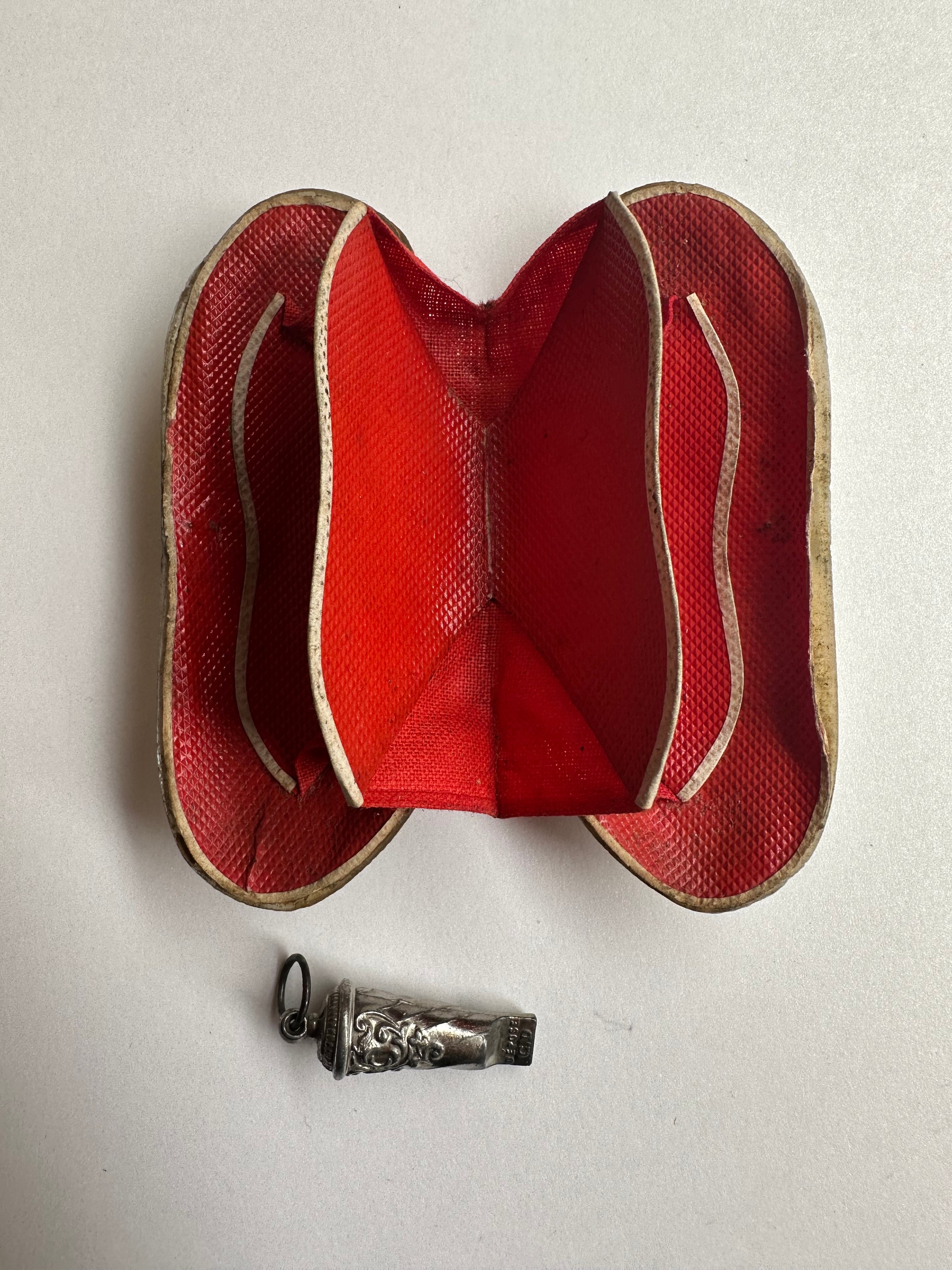 An early 20th century clam shell hinged purse with red lining along with a French miniature whistle. - Image 2 of 4