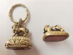 Two Victorian yellow metal plated fob seals, one with a carved lion finial and scrolling foliate