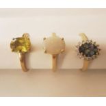 Three 20th century 10 carat gold gem-set rings: a white opal solitaire ring, a grey sapphire and