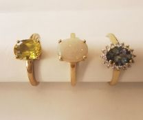 Three 20th century 10 carat gold gem-set rings: a white opal solitaire ring, a grey sapphire and