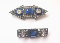 Two Art Deco French silver paste set brooches. One in the form of a double headed arrow with blue