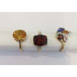 Three 20th century 10 carat gold gem-set rings: a Garnet solitaire ring, a yellow stone solitaire