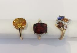 Three 20th century 10 carat gold gem-set rings: a Garnet solitaire ring, a yellow stone solitaire