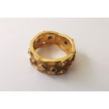 A 22 carat yellow gold wide scalloped band set with clear and black stones, engraved detailing the