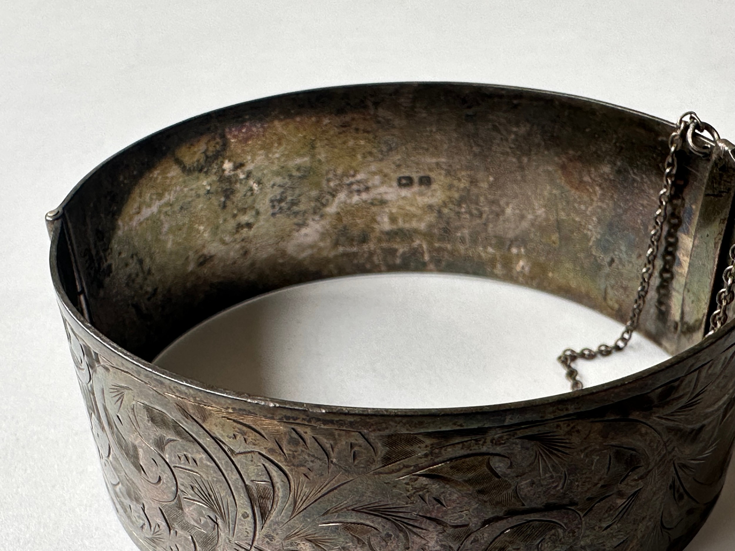 An Art Deco engraved wide silver bangle, decorated with scrolling foliate design. Fastens with a - Image 2 of 3