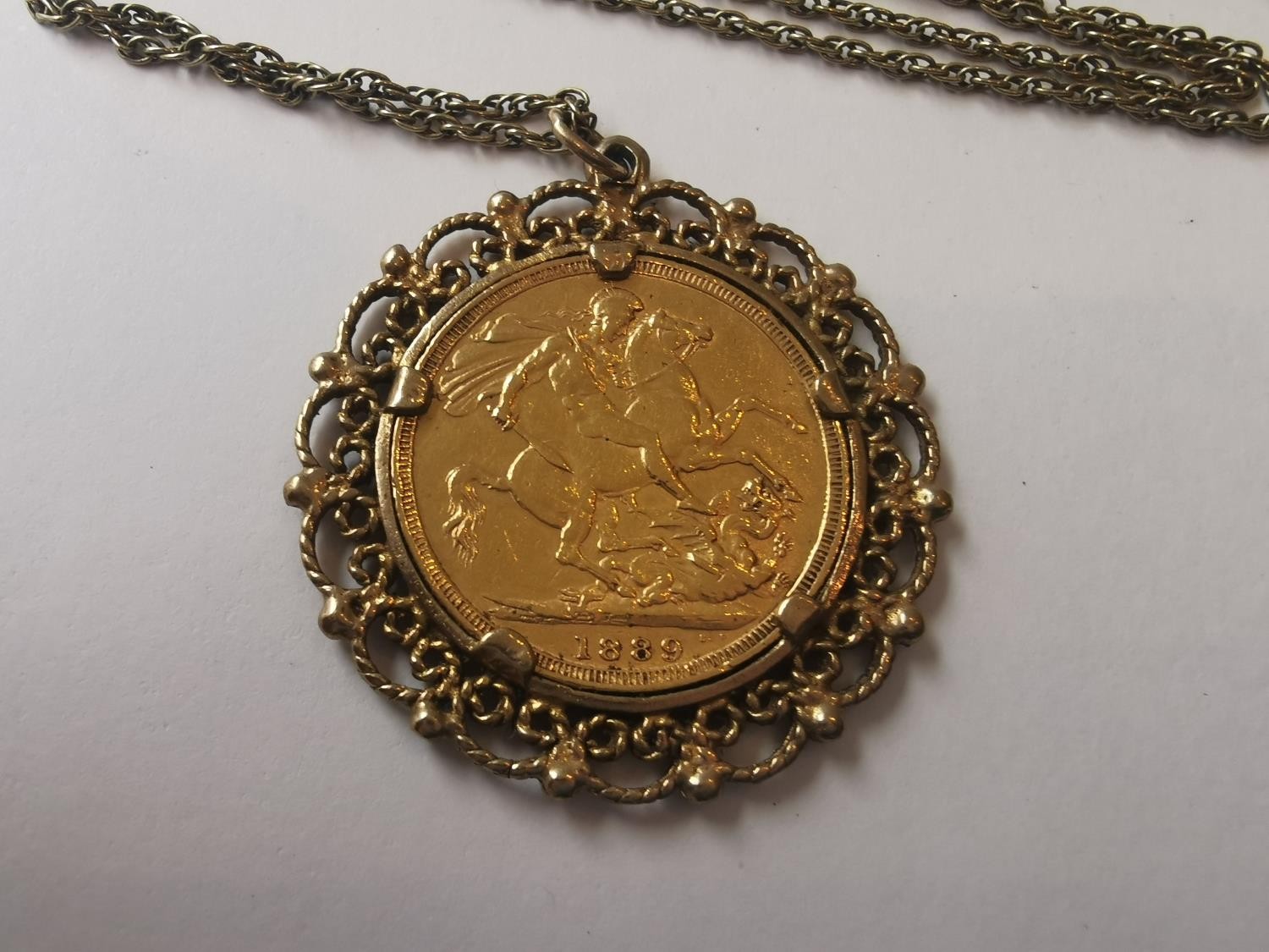 An 1889 Victorian full sovereign in filigree wirework mount on a 9 carat yellow gold rope chain. ( - Image 2 of 4