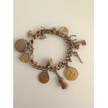A 9 carat rose gold curb link charm bracelet with engraved heart padlock clasp. Bracelet has 13
