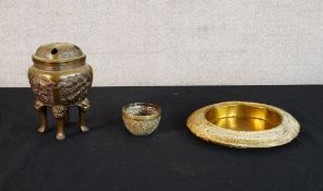 A late 19th/early 20th century brass koro raised on straight supports with mythical creatures,