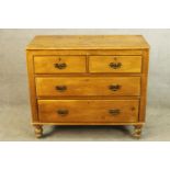 A late 19th century pine chest of two short over two long drawers with brass swing handles raised on