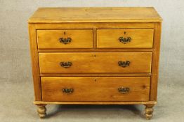 A late 19th century pine chest of two short over two long drawers with brass swing handles raised on