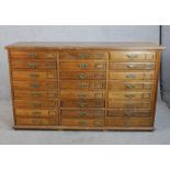 A late 19th century oak collectors cabinet of twenty four drawers with brass swing handles and