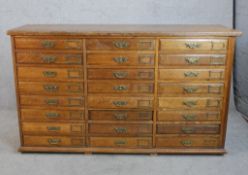 A late 19th century oak collectors cabinet of twenty four drawers with brass swing handles and