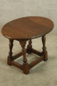 A Jacobean style oak drop leaf occasional table raised on turned stretchered supports. H.46 W.64 D.