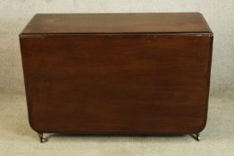A 19th century mahogany drop flap gateleg table raised on turned supports terminating in brass